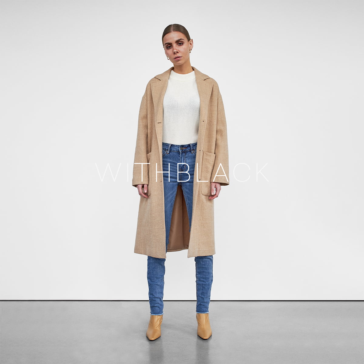 Model in Wollmantel, Kaschmirpullover und Jeans